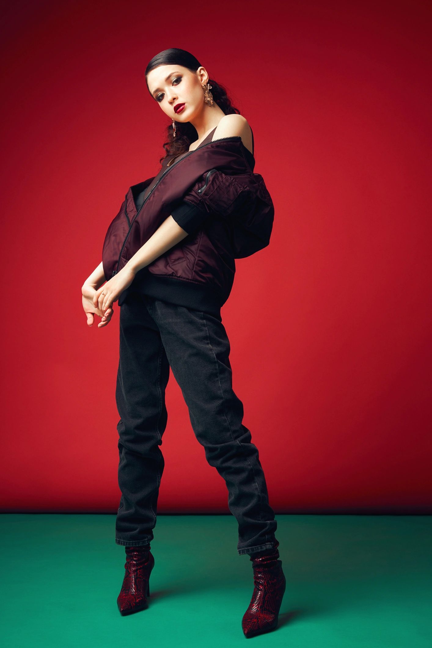 Model posing in stylish clothes on red background