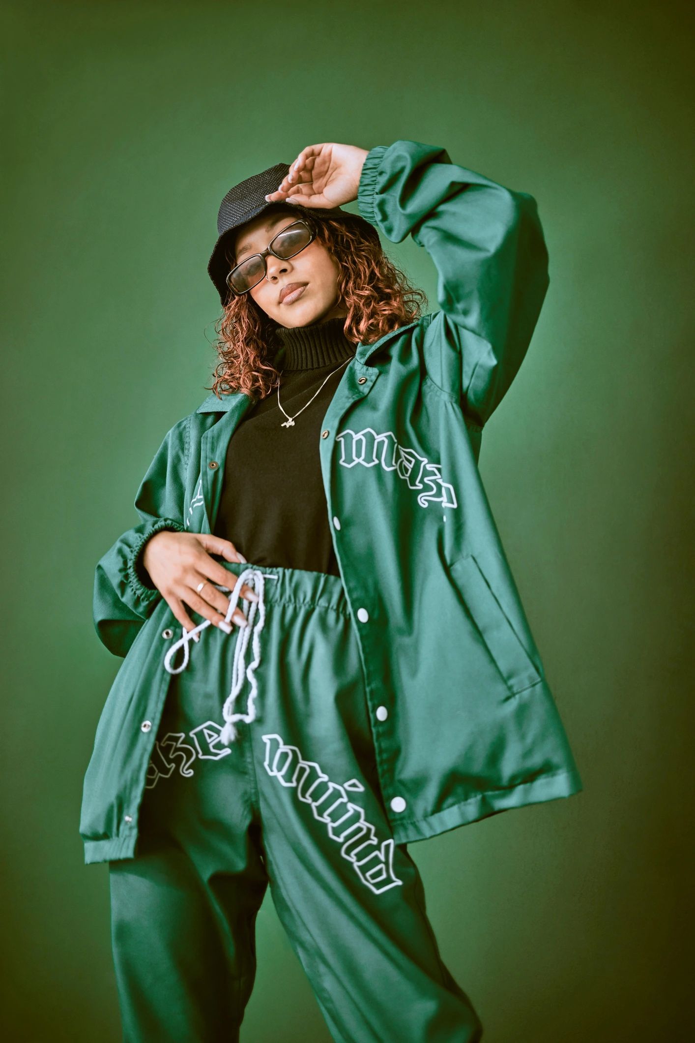 Fashion model in edgy green outfit on green background