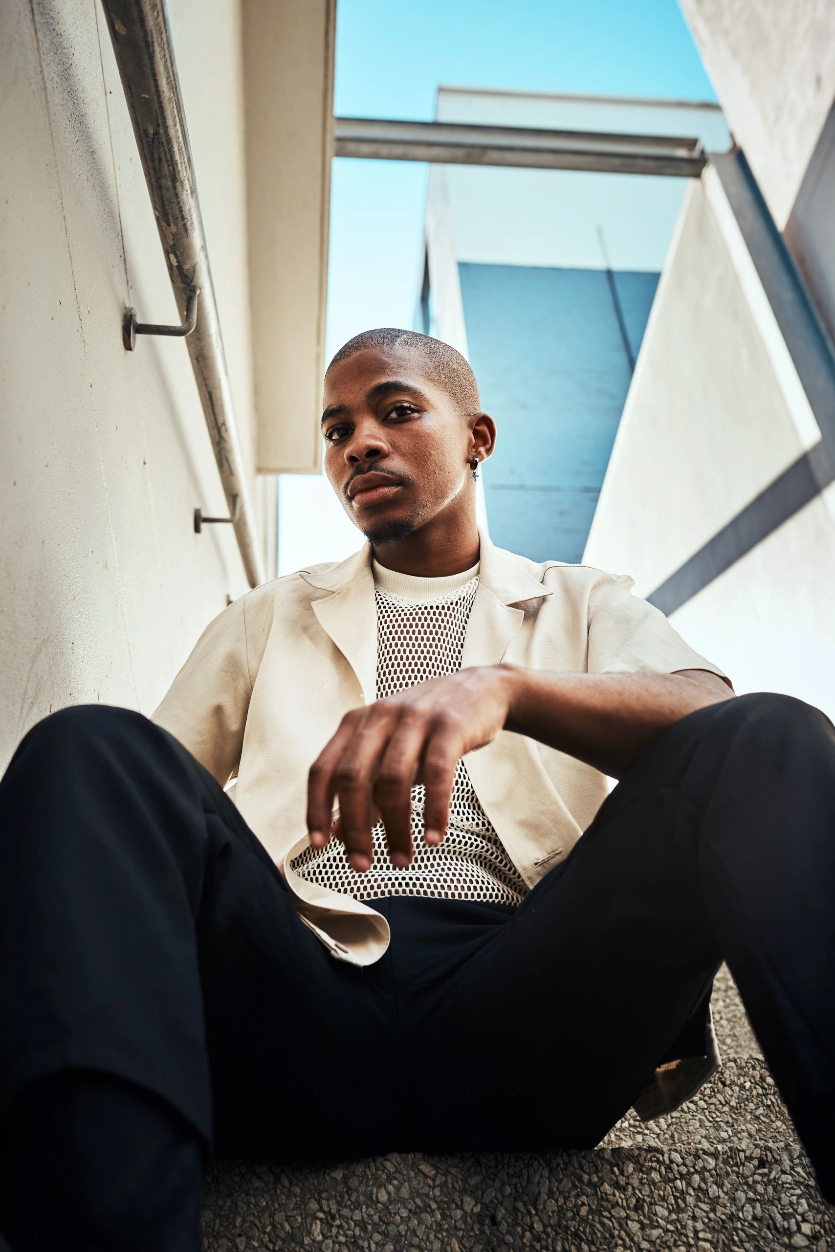Stylish young man sitting on urban staircase